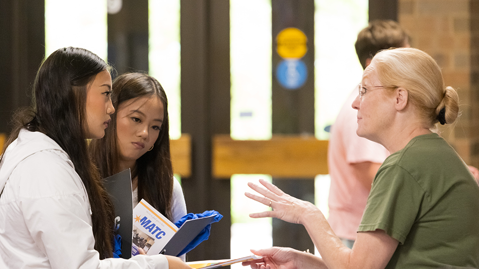 students getting help from an MATC staff member