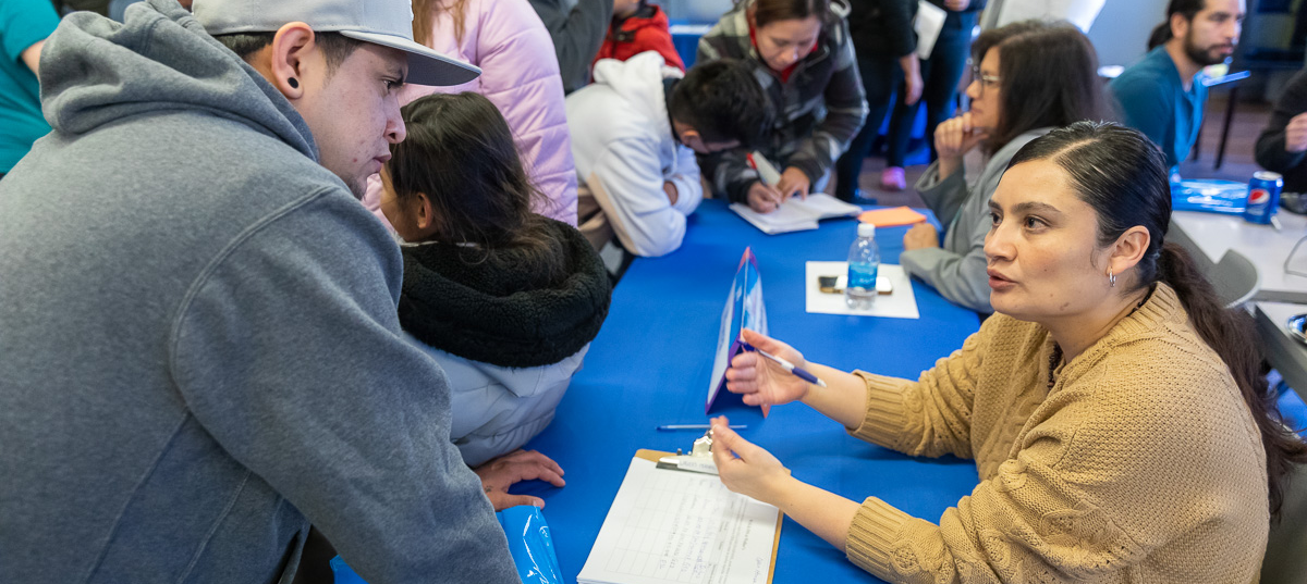 A hispanic MATC employee helps a prospective Latino student at an open house