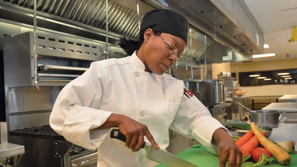 student chopping vegetables