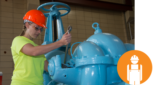 student with hard hat working in an industrial plumbing facility