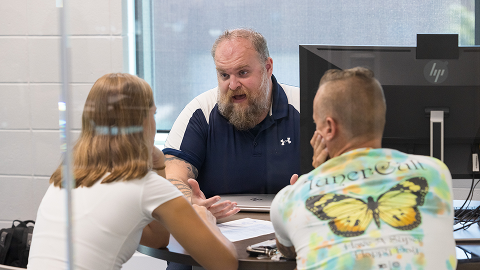 An MATC employee talks students at an Advising desk