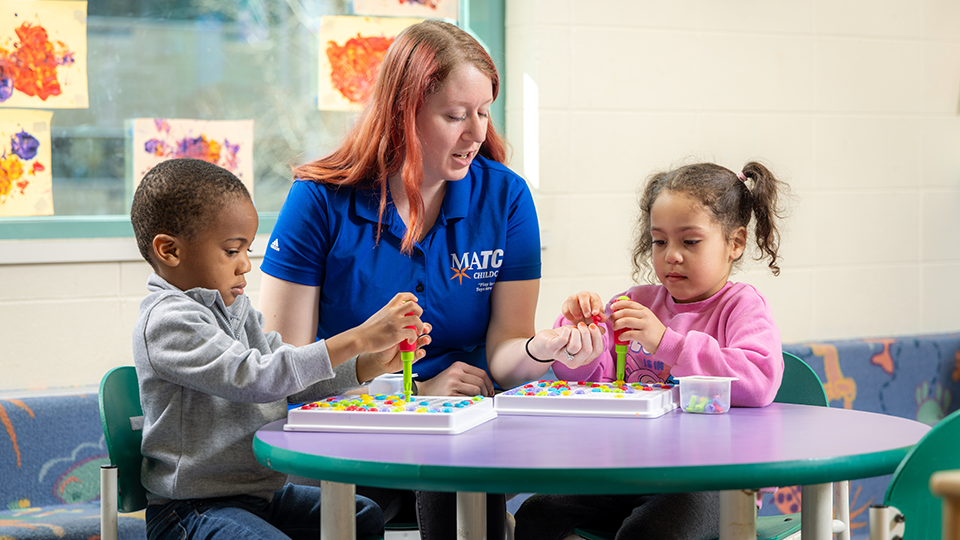 children at table with childcare worker