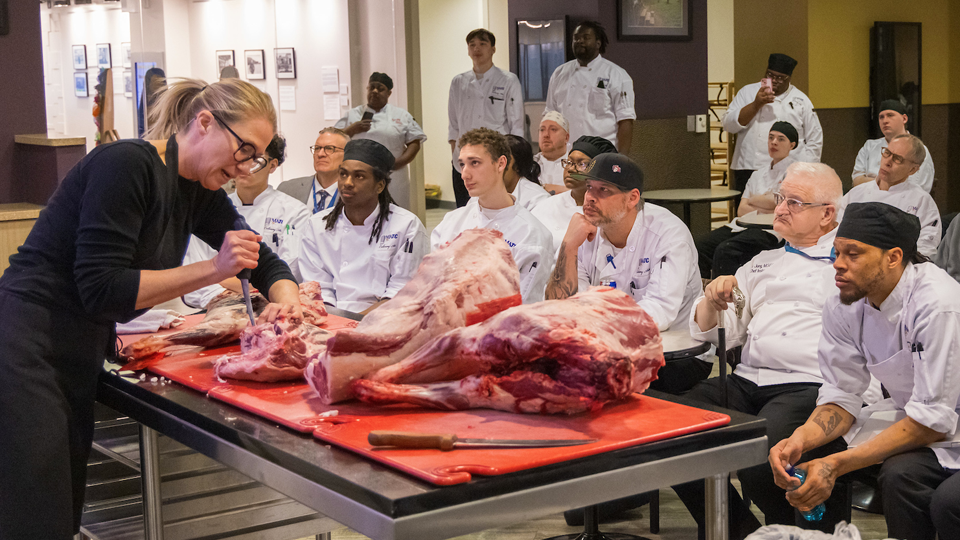Karen shows students how to cut a lamb